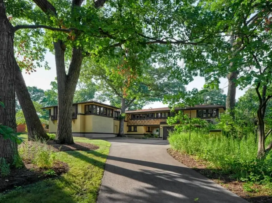 Prairie House Style: Key Features, History, and What Makes These Homes So Timeless 7 Yellow stucco and dark timber banding on a Prairie house exterior among mature trees