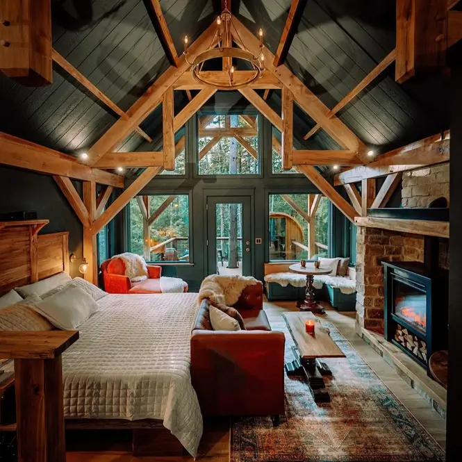 55 Treehouse Design Ideas, From Backyard Platforms to Canopy Cabins 52 Treehouse design ideas interior with exposed timber king post trusses, dark ceiling boards and full-height forest glazing