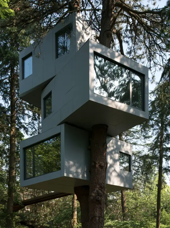 55 Treehouse Design Ideas, From Backyard Platforms to Canopy Cabins 9 Modern treehouse design ideas with two offset grey panelled volumes wrapped around a pine trunk and steel climbing rungs