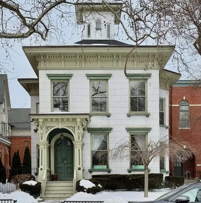 Italianate Style House: 33 Ideas and the Details That Give One Away 11 White stone Italianate style house with a square belvedere, dentil cornice on paired brackets and green window crowns