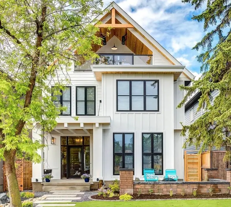 47 White Houses With Black Trim and Wood Accents We Love 11 White house with black trim and wood accents featuring a cedar-lined gable and exposed timber truss