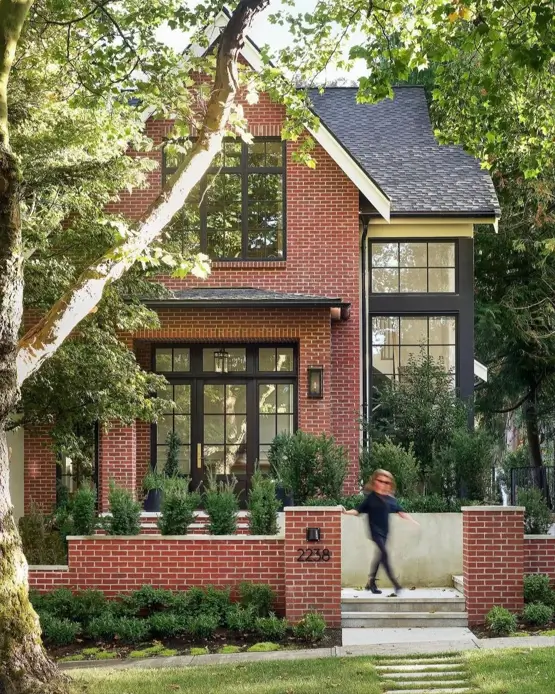 46 Red Brick House With Black Trim Ideas for Standout Curb Appeal 3 Red brick house with black trim and tall black-framed windows on a modern facade