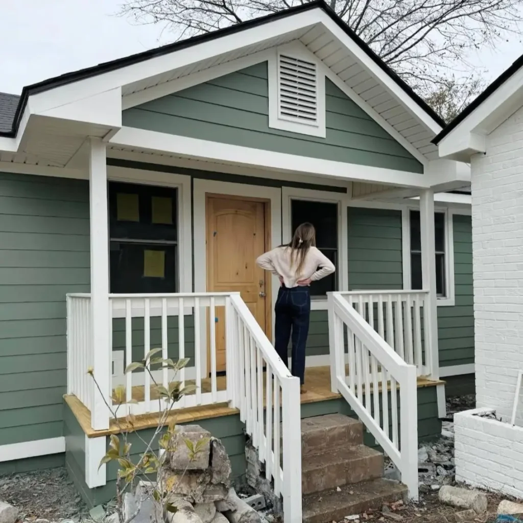 43 Green House With White Trim Ideas for Fresh Curb Appeal 3 sage green house with white trim, porch posts, and natural wood door on a small craftsman bungalow