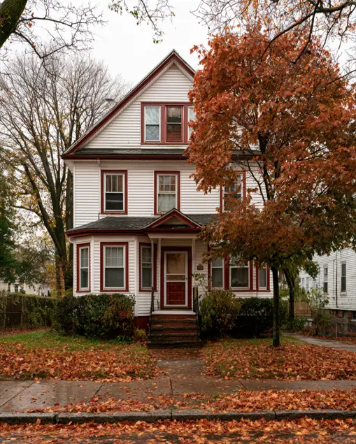 White House with Red Trim: 27 Ideas and How to Pick Your Red 14 White clapboard Victorian with wine-red window trim and a red front door among autumn leaves