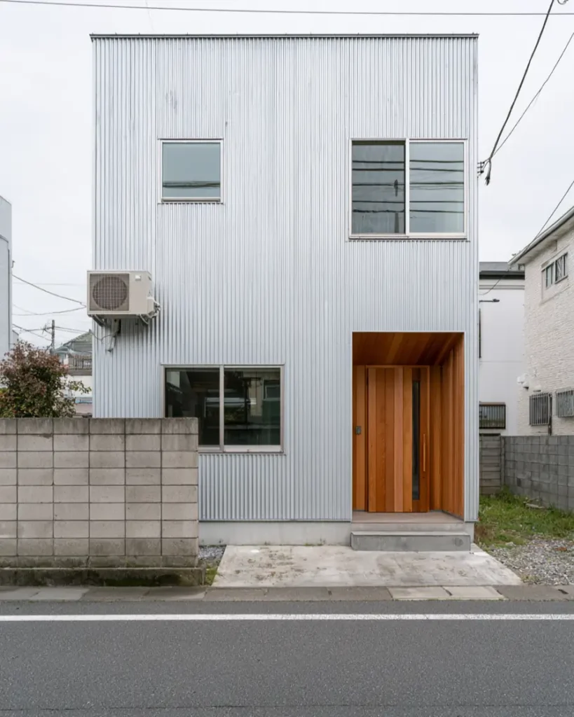 Modern Japanese House Design: 58 Ideas, Costs, and What Defines the Style 15 Pale corrugated galvalume siding with a cedar-lined entrance recessed into the wall.