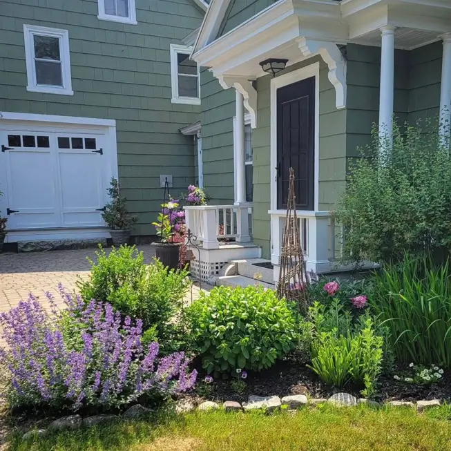 43 Green House With White Trim Ideas for Fresh Curb Appeal 15 olive green house with white trim and a black front door framed by white columns and a cottage garden
