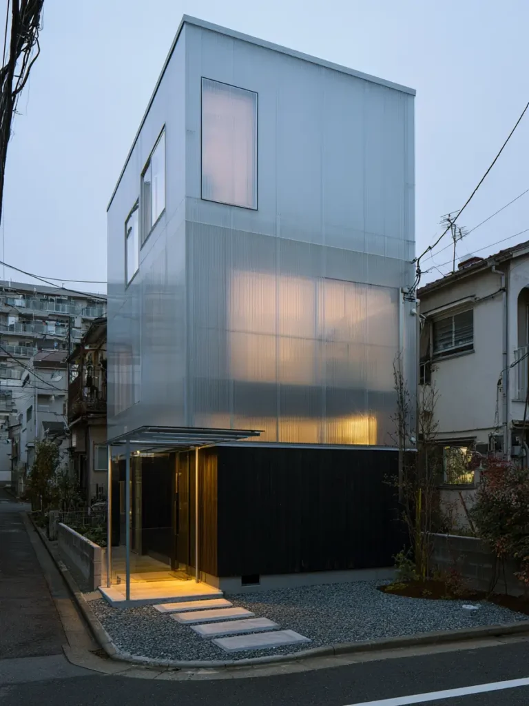 Modern Japanese House Design: 58 Ideas, Costs, and What Defines the Style 18 Translucent polycarbonate cladding above a charred timber base, glowing softly at dusk.