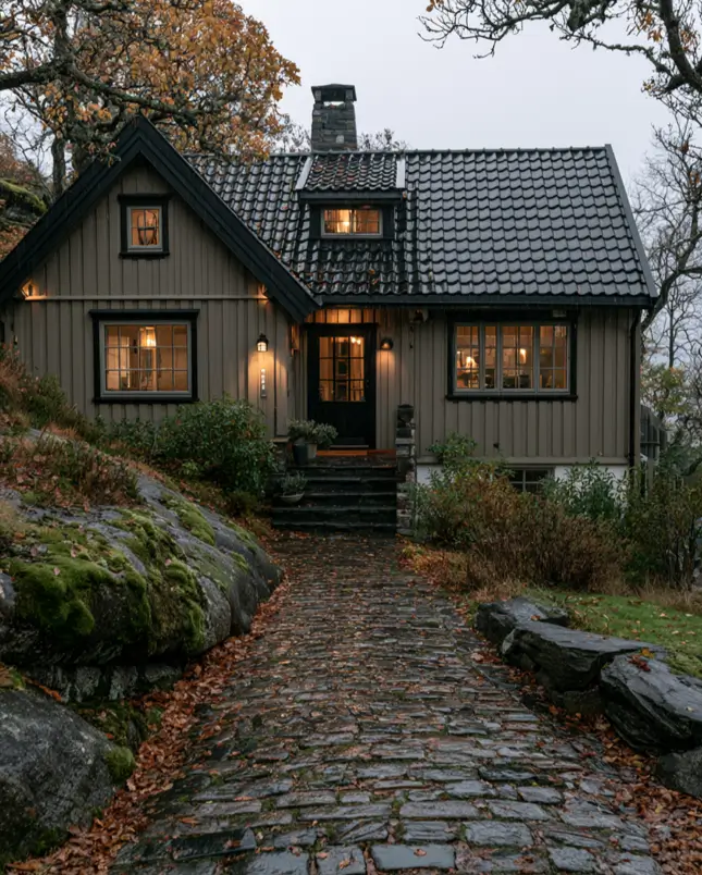 Taupe House With Black Trim: 28 Ideas + Best Paint Colors 20 Taupe house with black trim on a cozy taupe cottage with black windows and a dark tile roof at dusk