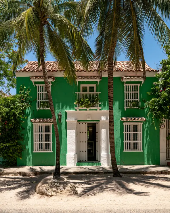 43 Green House With White Trim Ideas for Fresh Curb Appeal 26 emerald green house with white trim, mullioned window surrounds, and terracotta tile roof on a Spanish colonial