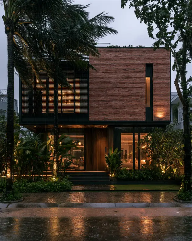 46 Red Brick House With Black Trim Ideas for Standout Curb Appeal 26 Modern red brick house with black trim and a tall vertical light slot at dusk