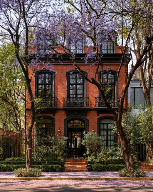 46 Red Brick House With Black Trim Ideas for Standout Curb Appeal 41 Red brick townhouse with black trim and tall arched windows behind an iron balcony
