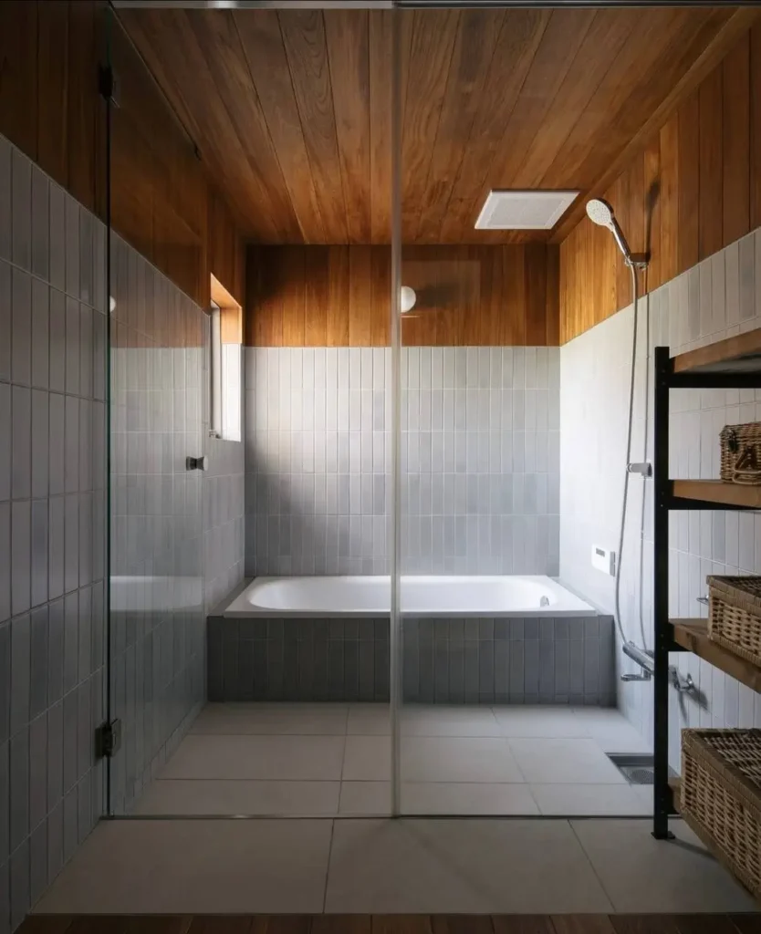 Modern Japanese House Design: 58 Ideas, Costs, and What Defines the Style 58 A modern Japanese house bathroom as a full wet room, with a deep tiled soaking tub, teak ceiling, and white tile walls.