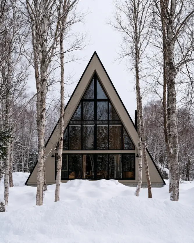 Taupe House With Black Trim: 28 Ideas + Best Paint Colors 8 Taupe house with black trim on a modern A-frame cabin with a black-framed glass gable in the snow