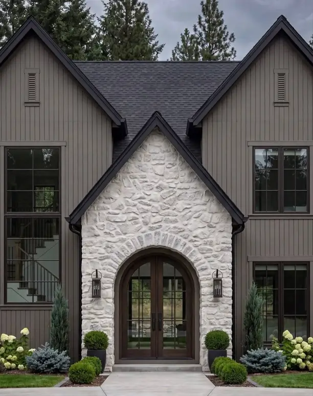 Taupe House With Black Trim: 28 Ideas + Best Paint Colors 9 Taupe house with black trim on a dark taupe board-and-batten home with a light stone arched entry