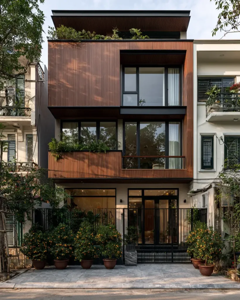 37 Brown House with Black Trim Ideas for a Warm, Modern Exterior 10 Warm brown timber-batten townhouse with black-framed windows and a dark street gate above a glazed base