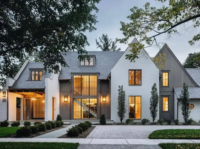 Modern Grey and White House Exterior: 30 Two-Tone Ideas 2 Modern grey and white house exterior with white painted brick, grey wood siding gables, black-framed windows, and a warm lit entry at dusk