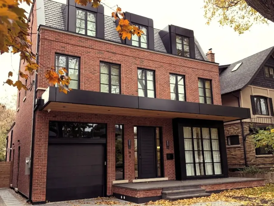 46 Red Brick House With Black Trim Ideas for Standout Curb Appeal 2 Modern red brick house with black trim, black dormers, black windows, and a black garage door