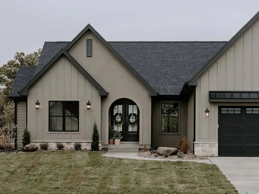 Taupe House With Black Trim: 28 Ideas + Best Paint Colors 2 Taupe house with black trim, greige board-and-batten and stucco with a black arched door, black windows, and a stone base