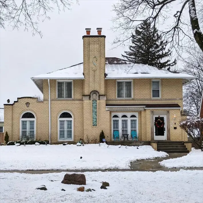 Blonde Brick House Ideas: 24 Warm Exteriors That Still Feel Fresh 3 Blonde brick house in Colonial style with glazed buff brick, white arched windows, and a teal tile accent band