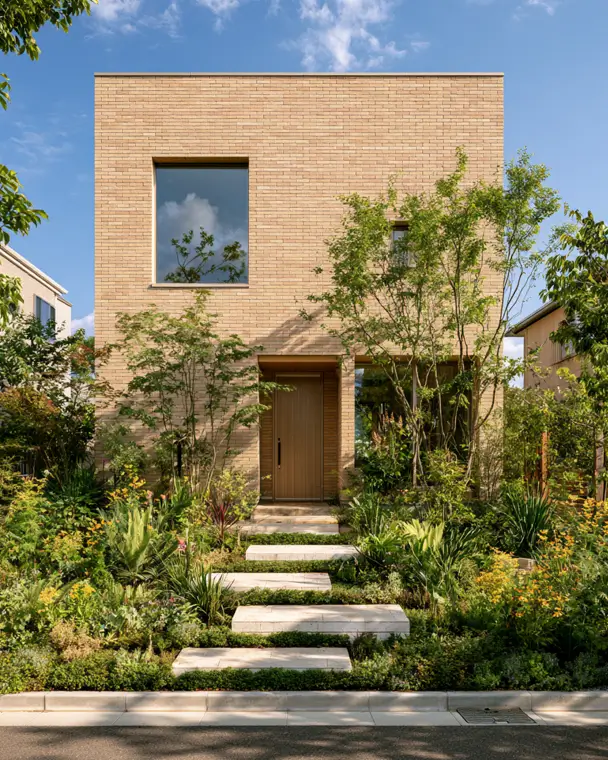 Blonde Brick House Ideas: 24 Warm Exteriors That Still Feel Fresh 8 Modern minimalist blonde brick house in a clean cube form with sandy brick, a flush wood door, and a lush garden