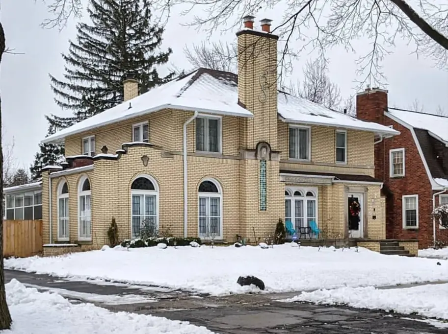 Blonde Brick House Ideas: 24 Warm Exteriors That Still Feel Fresh 43 Blonde brick house in Colonial style with glazed buff brick, white arched windows, and a snow-covered hipped roof